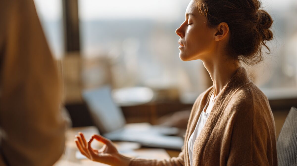 Employee practicing breathing technique at desk met coach guidance, nervous system regulation in workplace, calm hand gesture